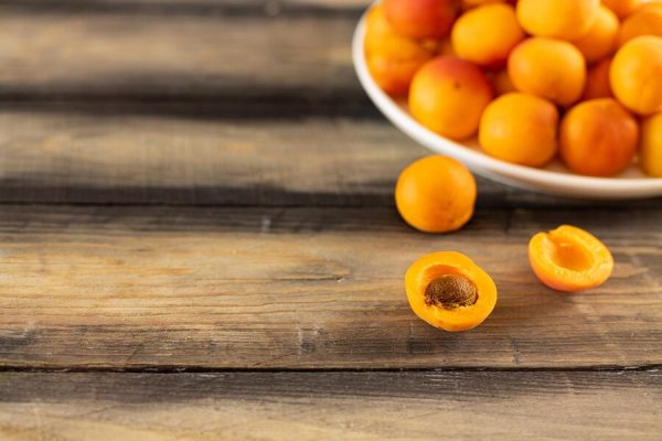 ripe-juicy-apricot-plate-wooden-table_564275-1034